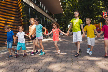 The group of excited preschoolers are running togetherの写真素材