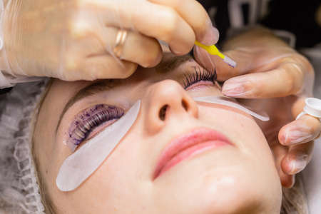 Female face under procedure of eyelashes lamination in beauty salonの写真素材