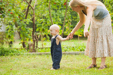 Mom and son spend time together in the summer gardenの写真素材