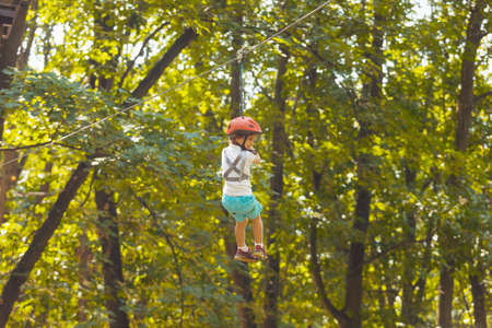 The little boy goes down the zipline in the parkの写真素材