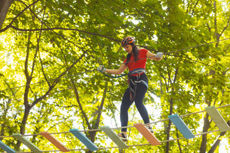 The woman is doing exercise in the adventure rope parkの写真素材
