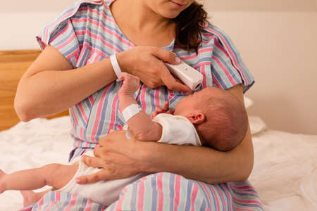Mom and her newborn baby in a modern hospitalの写真素材