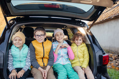 Mom and little boy sitting in hatchback car with mountain backgroundの写真素材