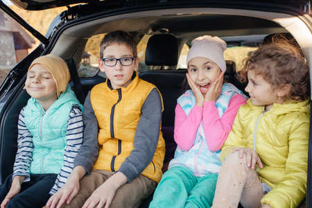 Mom and little boy sitting in hatchback car with mountain backgroundの写真素材