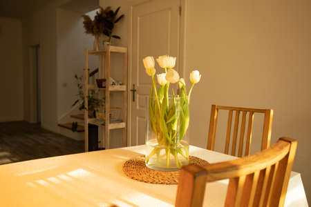 Spring flowers - white tulips in glass vase on wooden tableの写真素材