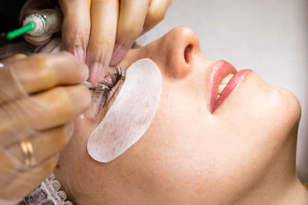 Female face under procedure of eyelashes lamination in beauty salonの写真素材