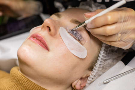 Female face under procedure of eyelashes lamination in beauty salonの写真素材