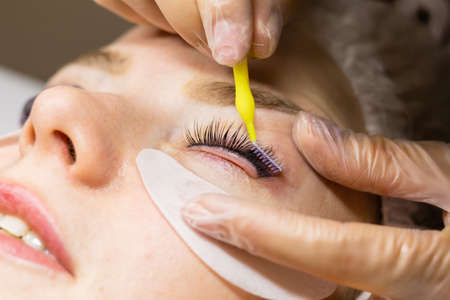 Female face under procedure of eyelashes lamination in beauty salonの写真素材