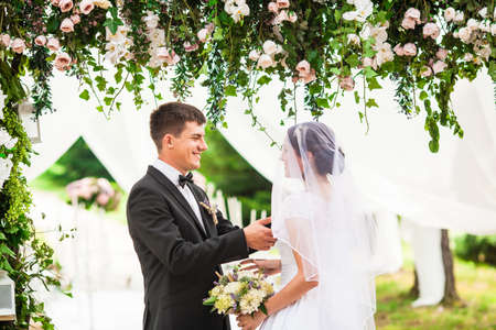 Wedding couple under the flower arch at the wedding ceremonyの写真素材