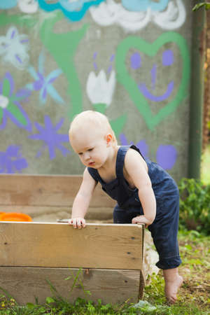The lonely baby is playing in the summer gardenの写真素材