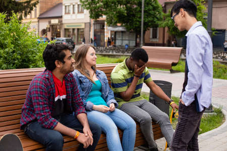 Diverse young men and woman spending free time together at parkの写真素材
