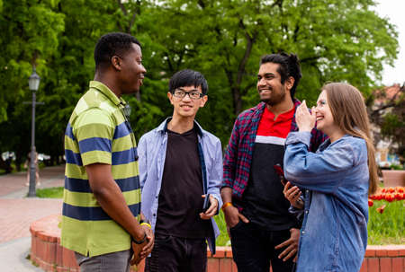 Diverse friends listening to young man telling storiesの写真素材