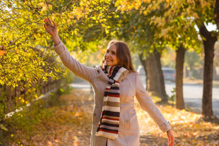 Happy woman wearing warm clothes in the parkの写真素材