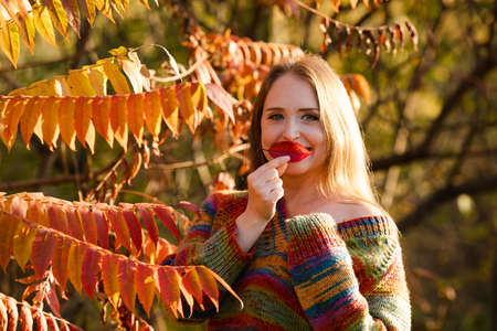 Happy woman wearing warm clothes in the parkの写真素材