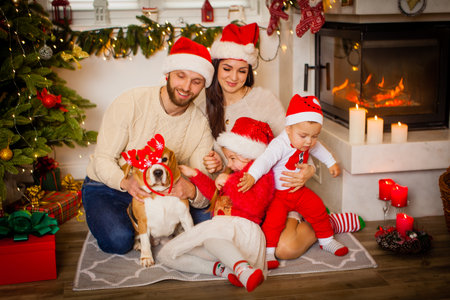 Family while sitting near beautiful Christmas tree at homeの写真素材