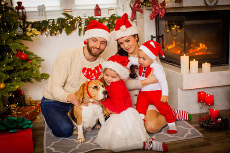 Family while sitting near beautiful Christmas tree at homeの写真素材