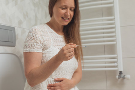 Confused middle age woman with pregnancy testの写真素材