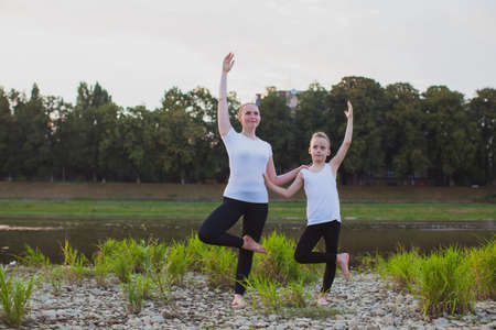 Son and mother are doing exercises in the parkの写真素材