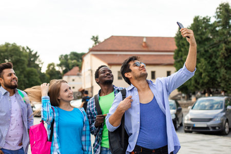 The joyful group of multiethnic students taking a selfie outdoorsの写真素材