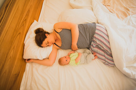 Mother and newborn baby sleep in the bed
