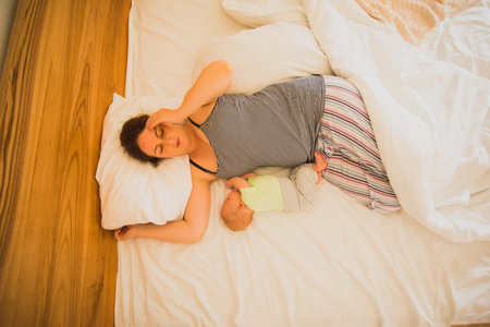 Mother and newborn baby sleep in the bed
