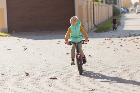 Boy at the bycicle walks at the streetの写真素材