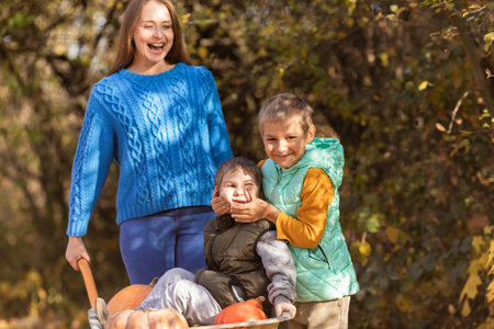 Mother have fun time with kids, use garden wheelbarrowの写真素材