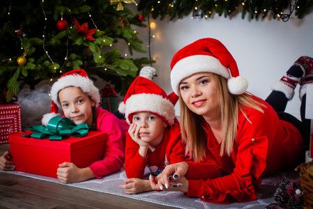 Happy family lying near the Christmas treeの写真素材