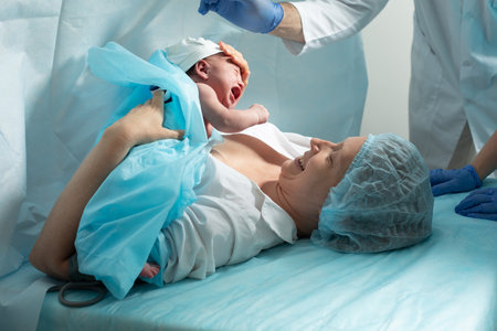 Mother holds newborn baby in hospital