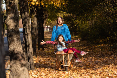 Mother have fun time with kid, use garden wheelbarrowの写真素材