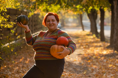 Plus size woman portrait with pumpkins outdoorの写真素材