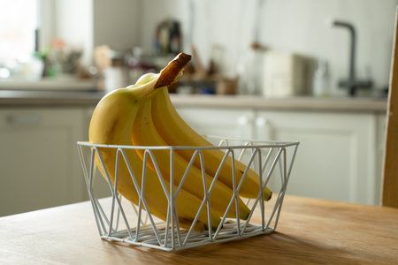Basket with fresh fruits on table in kitchenの写真素材