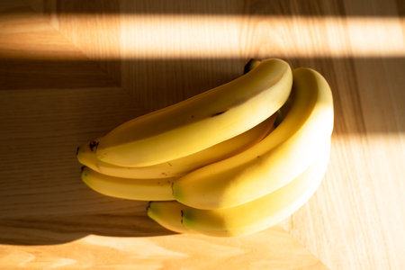 Bunch of bananas lying on the wooden backgroundの写真素材
