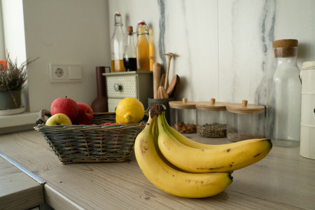 Basket with fresh fruits on table in kitchenの写真素材