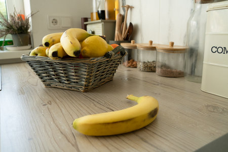 Basket with fresh fruits on table in kitchenの写真素材