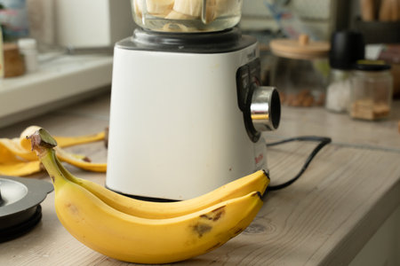 Vegan banana smoothie at the kitchen on the tableの写真素材