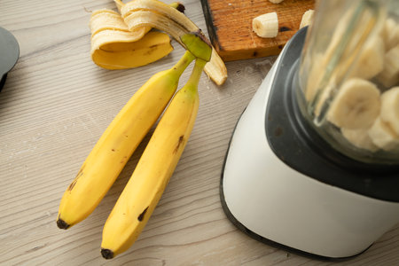 Vegan banana smoothie at the kitchen on the tableの写真素材