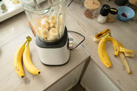 Vegan banana smoothie at the kitchen on the tableの写真素材
