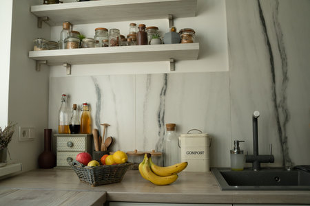 Basket with fresh fruits on table in kitchenの写真素材