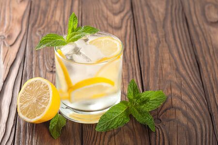 cool drink with lemon and mint on a wooden backgroundの写真素材