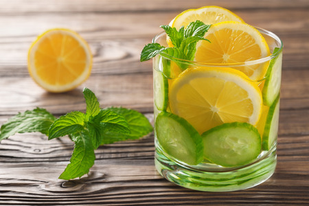 cool drink with lemon and mint on a wooden backgroundの写真素材