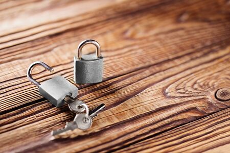 metal padlock with silvered keys on old wooden background. Estate and security concept with symbol...