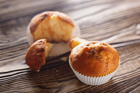 Classic muffins on a wooden old background in a white wrapper.の写真素材