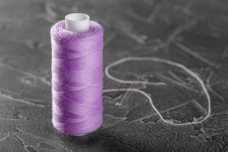 sewing thread on a bobbin of lilac colorの写真素材