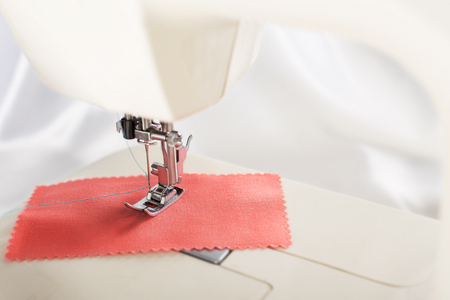 Tailoring process - sewing machine with needle, thread and fabric. Item of clothing.の写真素材
