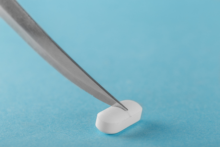 to divide the tablet with a knife into two parts concept medicinesの写真素材