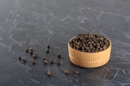 black ground pepper in a wooden bowlの写真素材