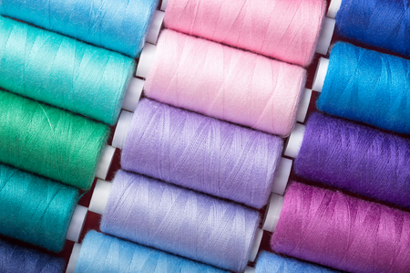 sewing thread in different colors pink blue green red
