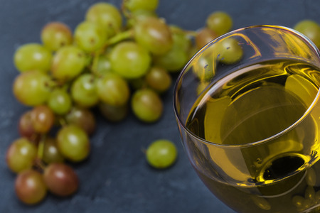 white wine in a glass with autumn grapesの写真素材