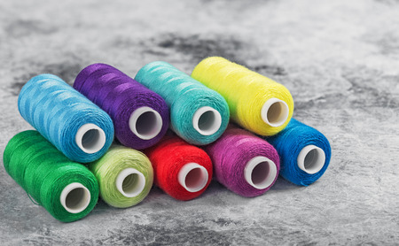Sewing threads on drums. A lot of colored threads for designers.の写真素材